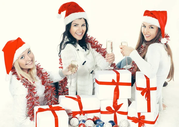 Closeup. три молоді жінки в капелюхах Санта-Клауса з різдвяними подарунками і склянками шампанського. . — стокове фото