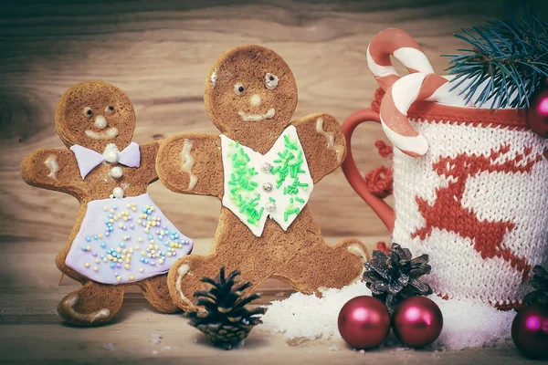 Schöne Weihnachtstasse und Lebkuchenmann auf Holztisch — Stockfoto