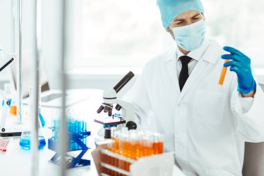 Kapat. Bir bilim adamının ellerinde test tüpü.