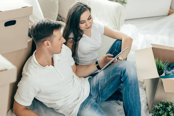 Pareja joven con un álbum de fotos de la familia en un nuevo apartamento. — Foto de Stock