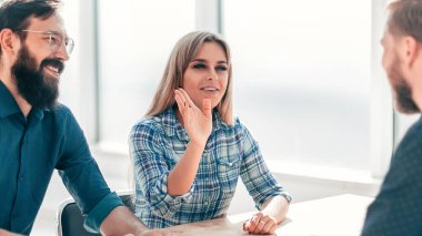 Ofis masasında oturan bir grup iş adamı.