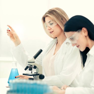 Genç bilim adamları laboratuvarda sıvıyı test ediyorlar.