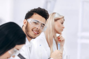 Yakın plan. Bir grup genç bilim adamı deneyler yapıyor.