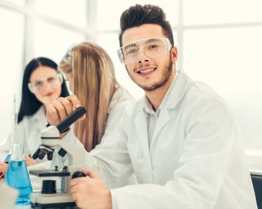 Laboratuvar masasında oturan bilim adamları..