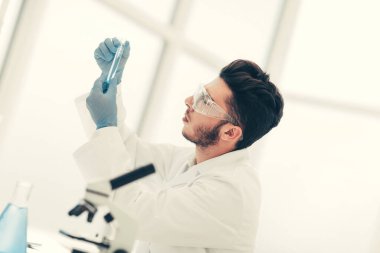 Kapat. Tıbbi tüplü bir bilim adamı laboratuvarda duruyor.