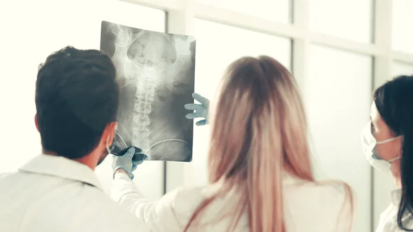 Vista trasera. un grupo de cirujanos discutiendo rayos X — Foto de Stock
