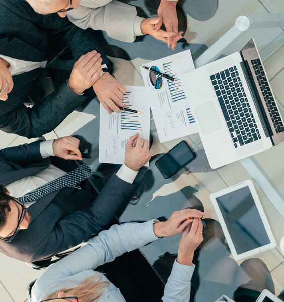 деловая женщина обсуждает финансовые данные с коллегами. вид сверху.