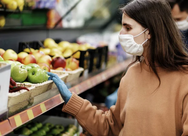 De près. femme en gants de protection choisir des fruits dans le magasin. — Photo