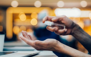 Kapat. Antiseptik sprey sıkan bir adam..