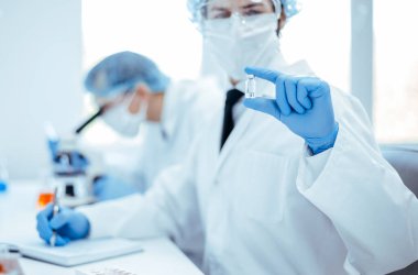 Bir bilim adamının arkaplan resmi test sonuçlarını bir laboratuvar günlüğünde kaydediyor.