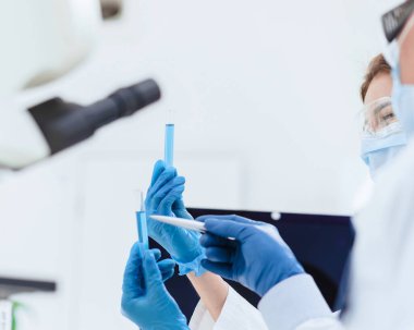 Kapat. Bilim adamının nehirlerinde test sonuçları olan tüpler..