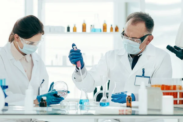 Cientista e assistente de laboratório conduzem pesquisa no laboratório. — Fotografia de Stock