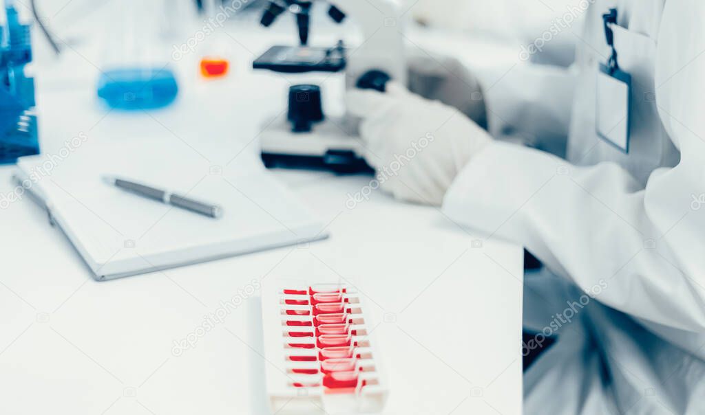 close up. image of a scientist looking through a microscope .