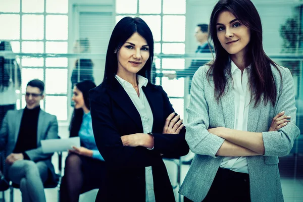 Dos jóvenes empresarias de pie en el cargo — Foto de Stock