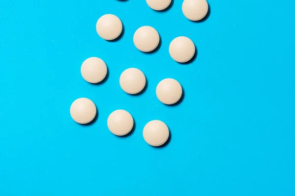 White round tablets on a blue background. — Stock Photo, Image