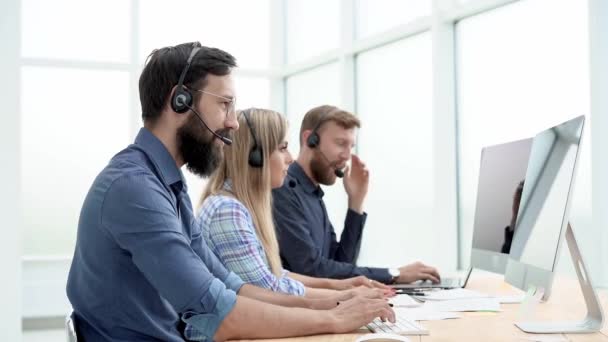 Grupo de funcionários do call center que se comunica com os clientes em linha. — Vídeo de Stock