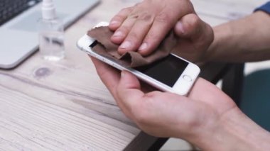 Adam akıllı telefonunun ekranını dikkatlice siliyor..