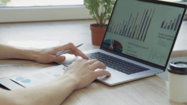 Kapat. Bir dizüstü bilgisayardaki finansal verileri analiz eden iş adamı.