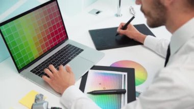 Tasarımcı bir dizüstü bilgisayar ve grafik tableti kullanarak çalışır .