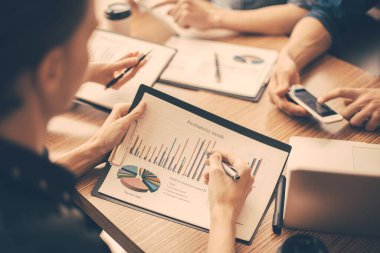 Kapat. İşyerinde mali belgeleri tartışan çalışanlar.