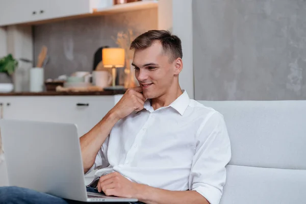 Jovem sorridente olhando para a tela de seu laptop . — Fotografia de Stock