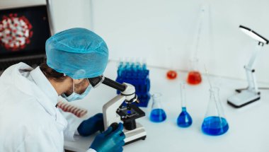Kapat. Bilim adamı yeni bir aşının örneklerini inceliyor. .