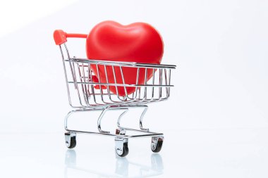 Alışveriş arabasında kırmızı kalp. fotokopi alanı olan bir fotoğraf.