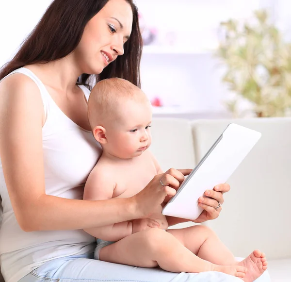Młoda matka z dzieckiem patrząca na ekran tabletu cyfrowego. — Zdjęcie stockowe
