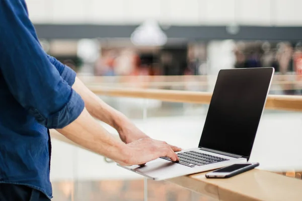 Fecha. um jovem com uma máscara protetora usando um laptop — Fotografia de Stock