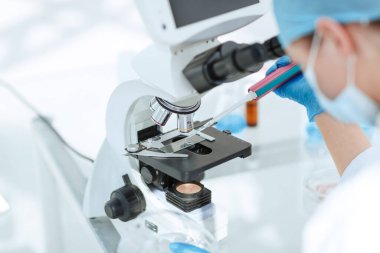 Kapat. Araştırmacı kanı mikroskop altında test ediyor..