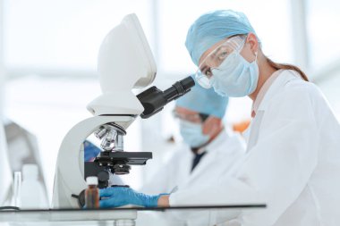 Bilim adamları sıvıyı test ediyor ve sonuçları laboratuvar dergisine yazıyorlar..