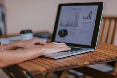 Kapat. İş kadını finansal verilerle çalışmak için dizüstü bilgisayar kullanıyor .