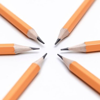 Beyaz arkaplanda daire şeklinde dizilmiş kalemler.