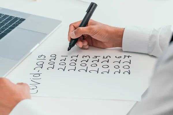 man making marks on a piece of paper. business development during coronavirus.