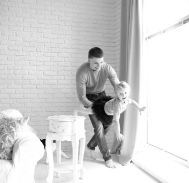 Sevgi dolu baba, oturma odasında kızıyla oynuyor..