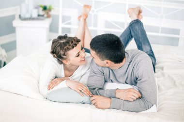 Genç, gülümseyen romantik çift birbirinin yanında rahatlıyor..