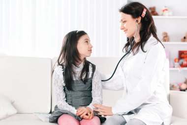 Çocuk doktoru, tedavi kurallarını küçük kıza kesin olarak açıklar.