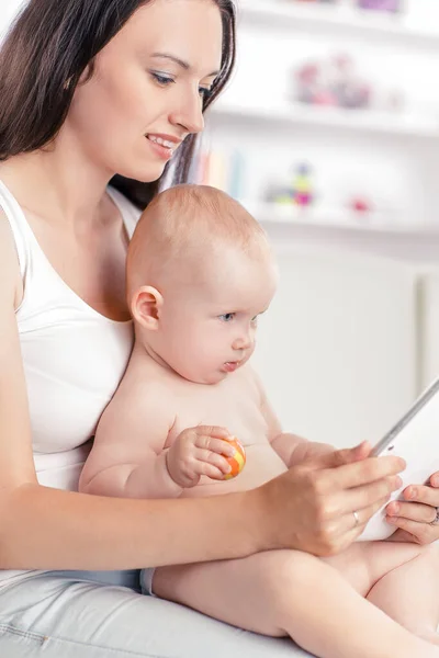 Mamá y el bebé están mirando la pantalla digital de la tableta — Foto de Stock