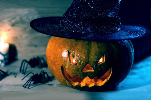 Läskig pumpa för Halloween i häxa hatt på trä bakgrund — Stockfoto