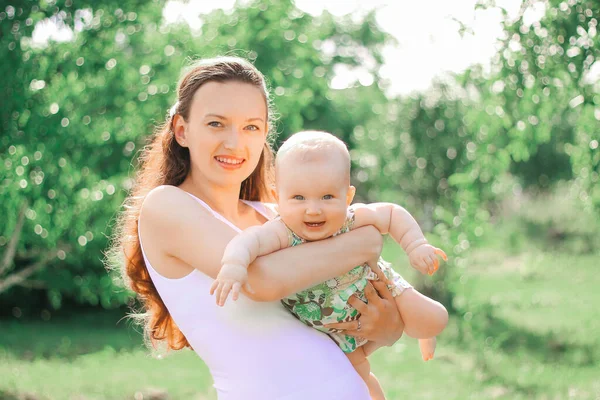 Uśmiechnięta matka bawiąca się ze swoją córeczką w Summer Park — Zdjęcie stockowe