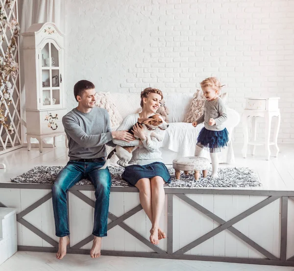 Retrato de uma família feliz e seu animal de estimação em uma sala de estar aconchegante — Fotografia de Stock