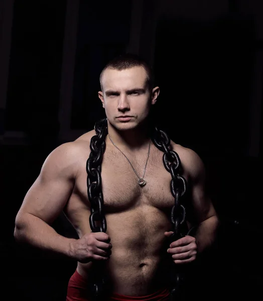 Retrato de un apuesto culturista masculino con una cadena alrededor de su cuello — Foto de Stock
