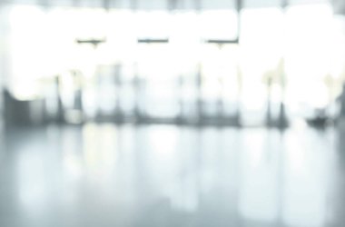 Cam duvarlı bir ofis lobisinin bulanık arkaplan görüntüsü.