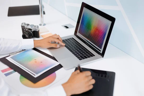 Diseñador trabaja con una paleta de colores mientras está sentado en una mesa. —  Fotos de Stock