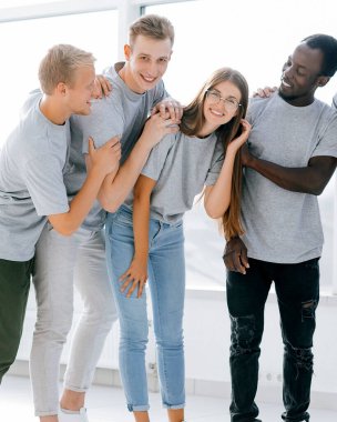 Genç profesyonellerden oluşan bir ekip parlak bir ofiste duruyor.