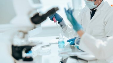 Kapat. Laboratuvarda sıvı örneklerini inceleyen bilim adamları.