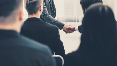 İş arkadaşları el sıkışarak birbirlerini selamlıyorlar.
