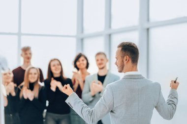 Dikiz aynası. İş adamı iş adamlarının önünde alkışlıyor.