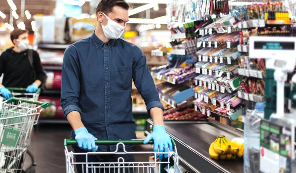 Groupe d'acheteurs dans des masques de protection debout près de la caisse dans un supermarché — Photo