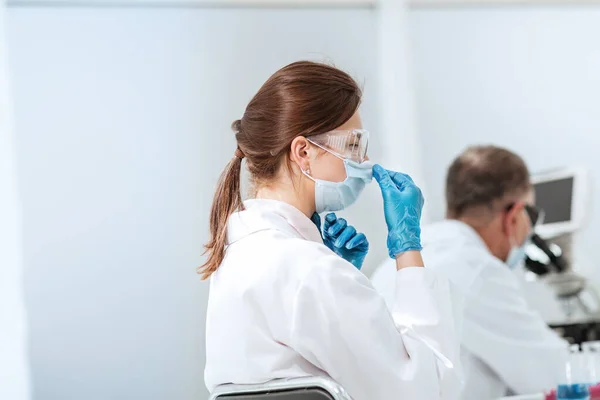 Zamknij się. kobieta naukowiec siedzi przy stole laboratoryjnym. — Zdjęcie stockowe